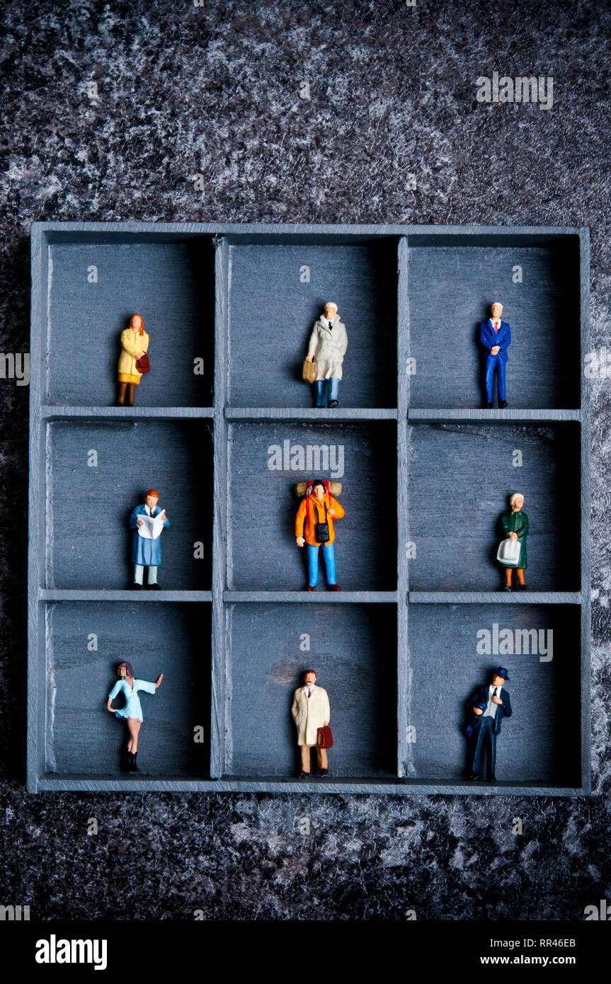 Miniaturfiguren in einer Box mit Fächern, Konzept für die Verstauung und soziale Distanzierung Stockfoto