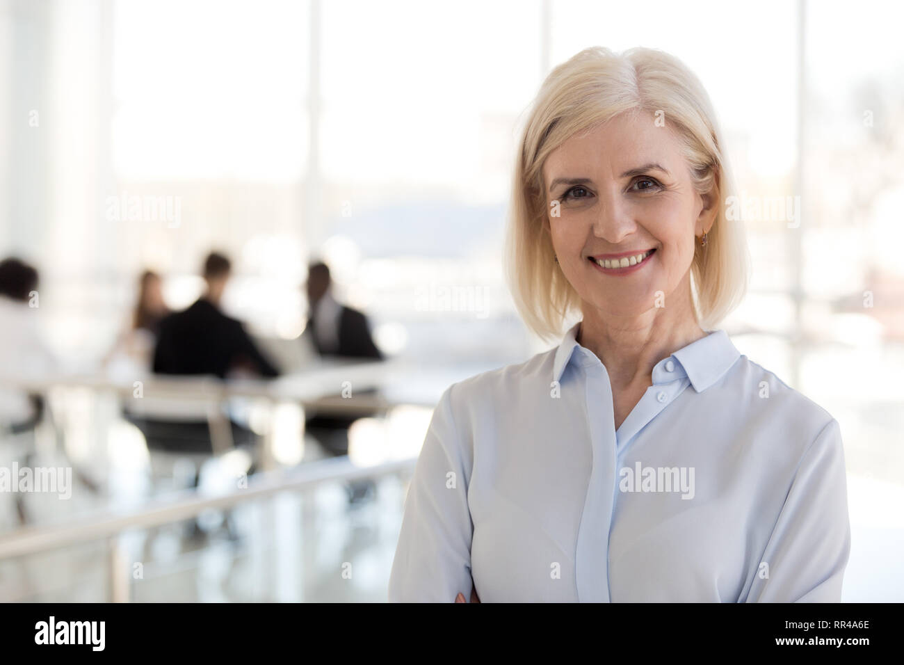 Glücklich, erfolgreich im Alter von Business Lady posiert an Kamera suchen Stockfoto