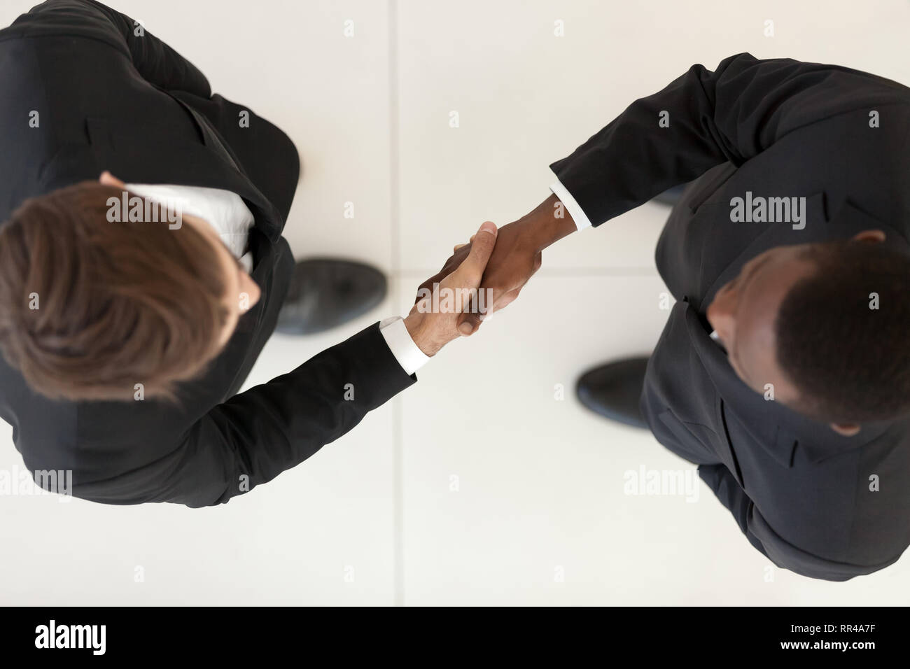 Ansicht direkt von oben diverse Geschäftsleute in Anzügen die Hände schütteln Stockfoto