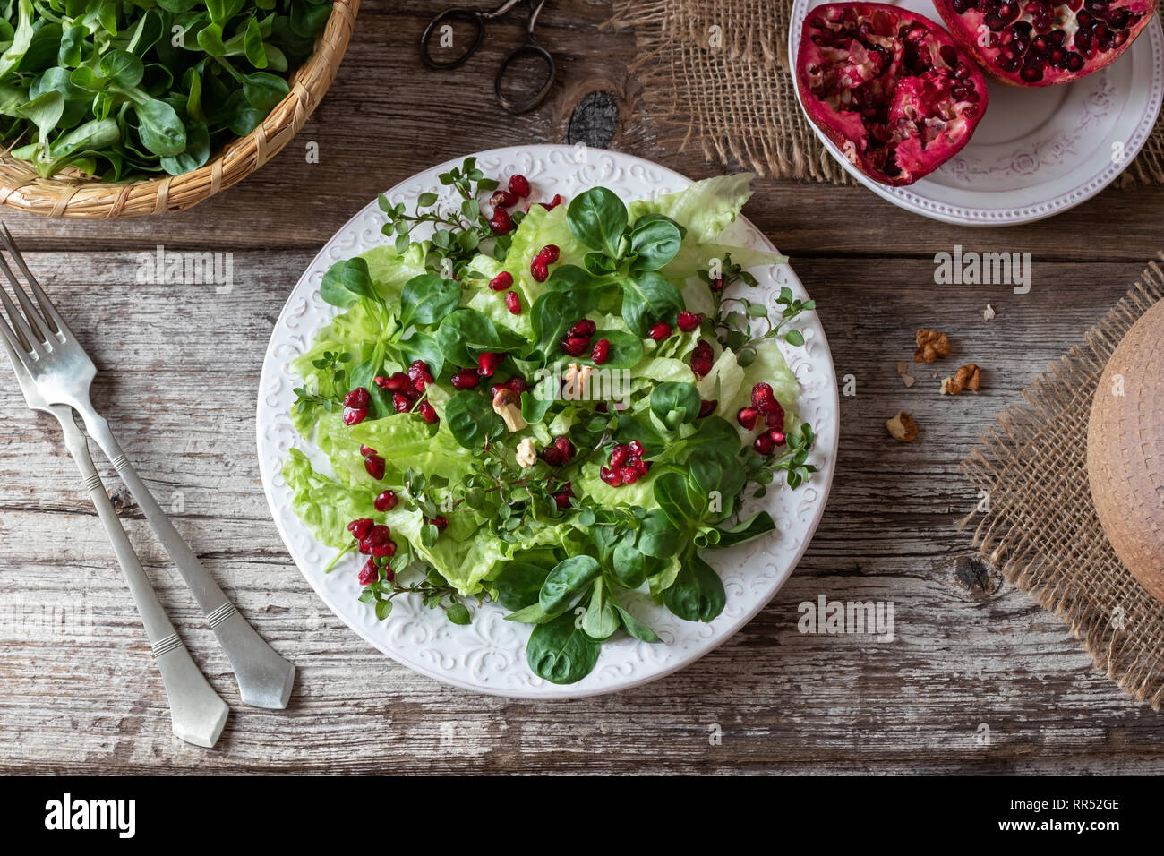 Frühlingssalat mit wilder Vogelmiere, Mutter Kopfsalat und Granatapfel Stockfoto