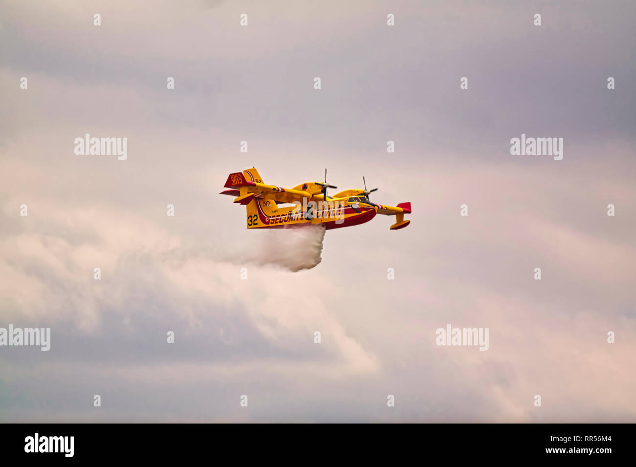 In LE BOURGET, Frankreich - 24. Juni 2017. Kleine gelbe rote Wasserflugzeug Wasserflugzeug fliegen in den Himmel mit Wolken droping Wasser auf der Internationalen Luft- und Stockfoto