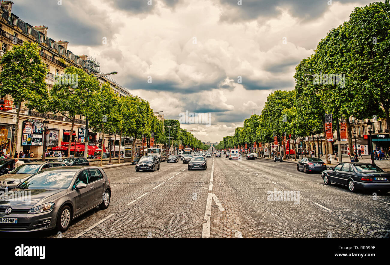 Paris, Frankreich - Juni 02, 2017: Avenue des Champs Elysees mit viel Verkehr. Elysian Fields Road an bewölkten Himmel. Urlaub und Reisen in die französische Hauptstadt. Stockfoto