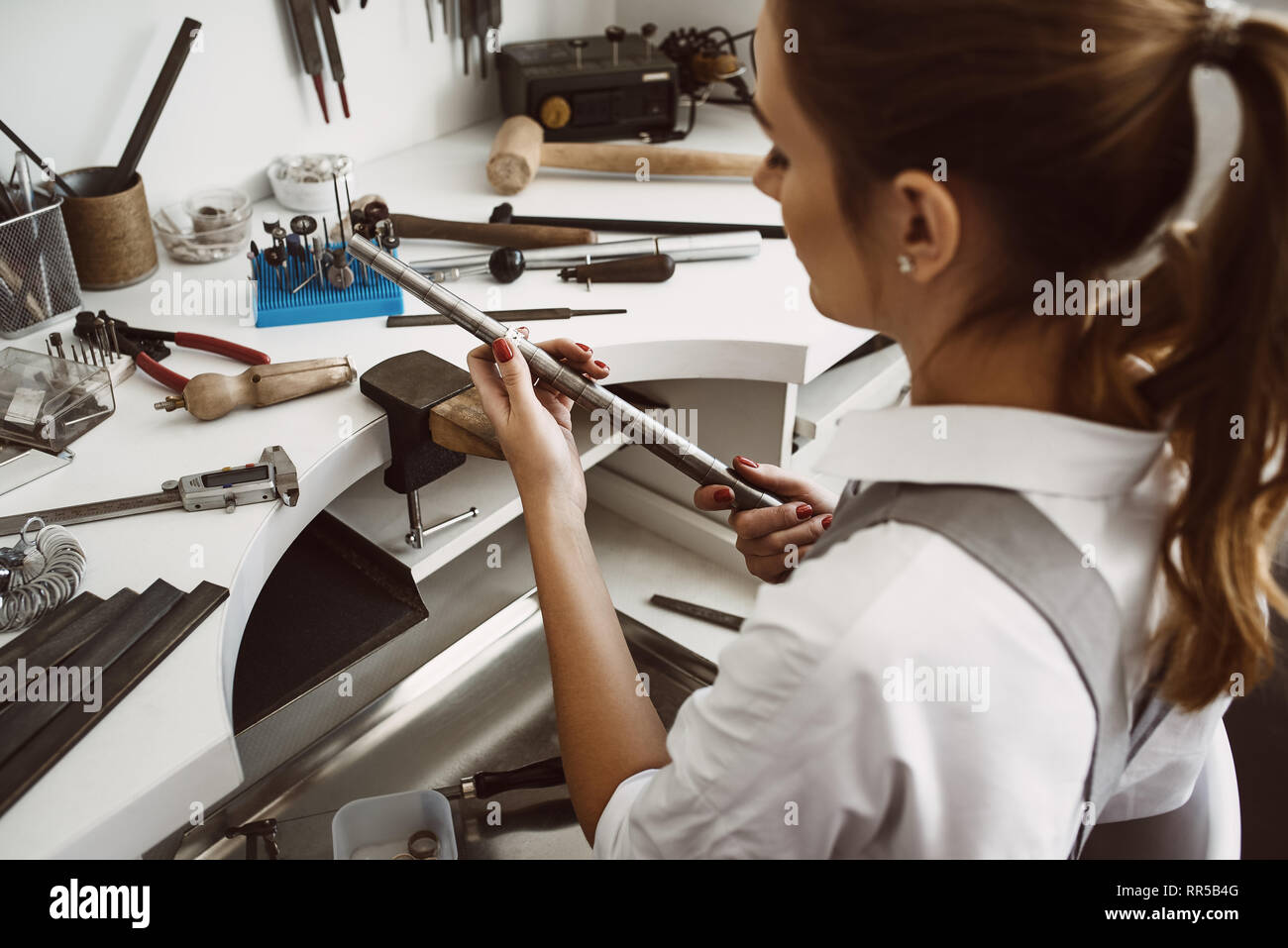 Richtige Größe. Portrait von weiblichen Schmuck Designer Messung ein Ring mit metall ring Sizer in ihrer Werkstatt Stockfoto