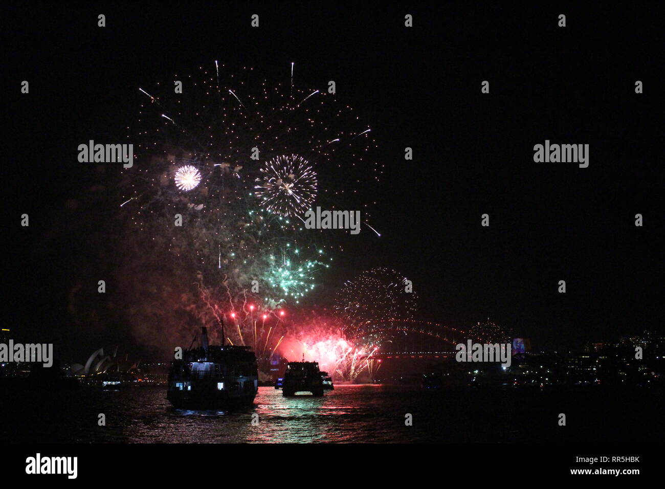 Silvester Feuerwerk im Hafen von Sydney mit hellen Spiegelungen im Wasser. Stockfoto