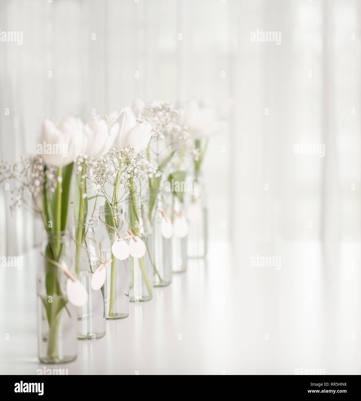 Weiße Tulpen in Flaschen mit Ostern Dekoration in Form von Eiern auf einem weißen Tisch. Selektive konzentrieren. Stockfoto