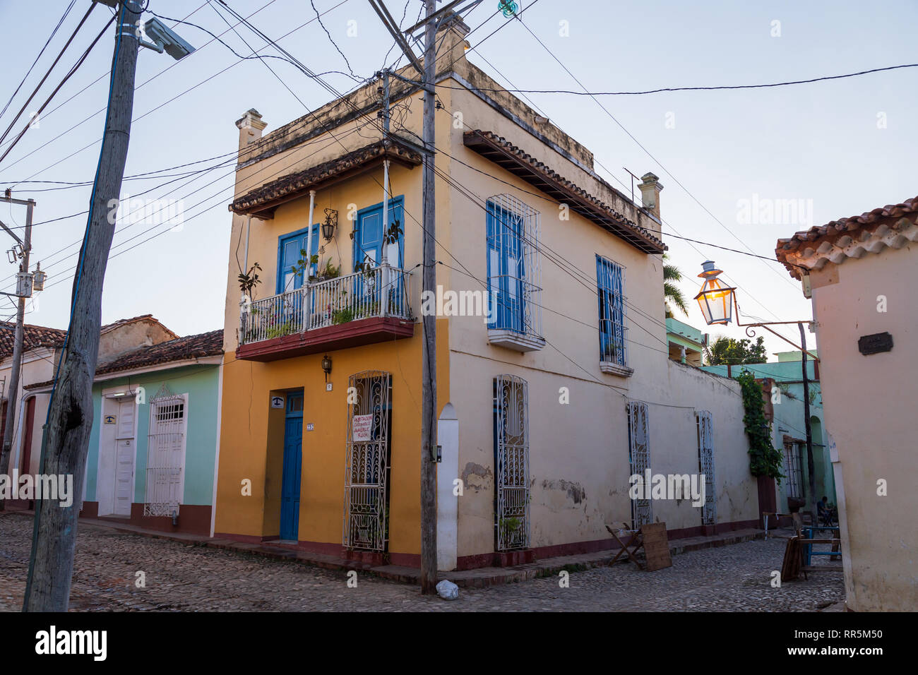 Ein typisch kubanisches Haus mit bunten Farben und blauen Fenstern und Kabel an der Ecke der Straße mit einem Schild Verfügbare Zimmer in Trinidad, Kuba Stockfoto