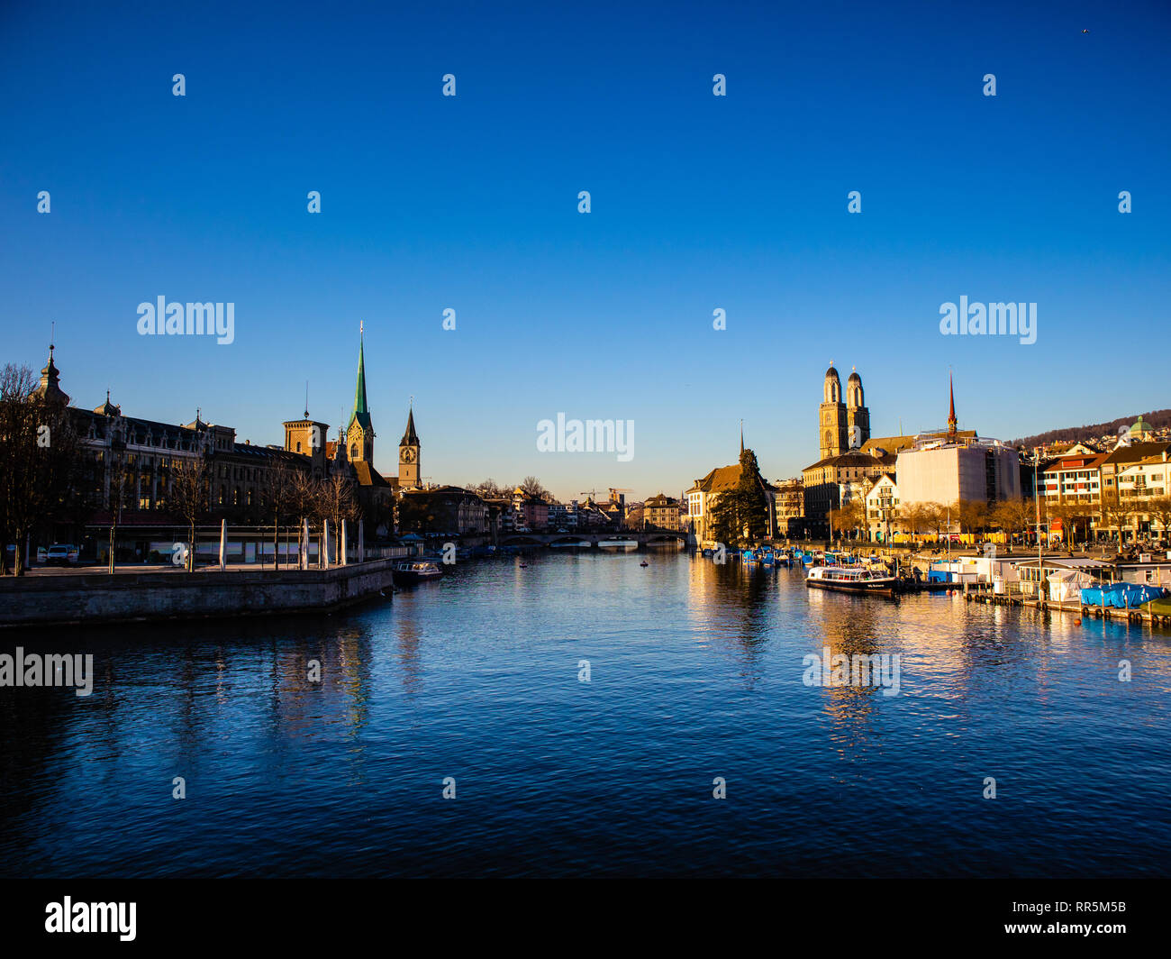 Blick auf die Altstadt der Stadt Zürich mit berühmten Fraumunster und Grossmünster Kirchen und Limmat am Zürichsee auf einem Sonnenuntergang im Winter, Schweiz Stockfoto