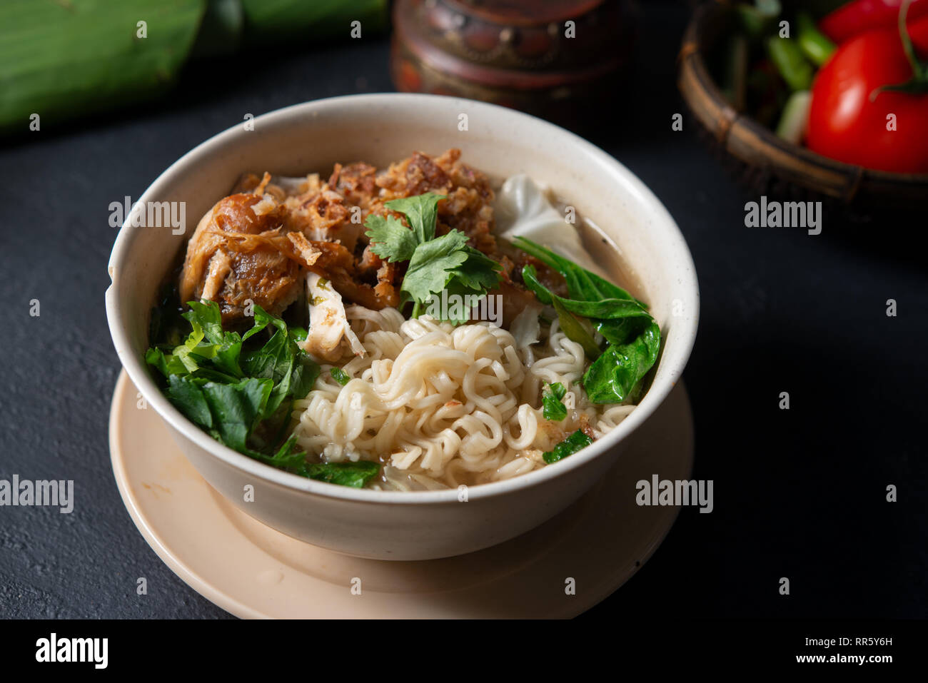Asiatische Ramen Nudeln Suppe und Hühnchen in der Schüssel auf dunklem Hintergrund. Stockfoto