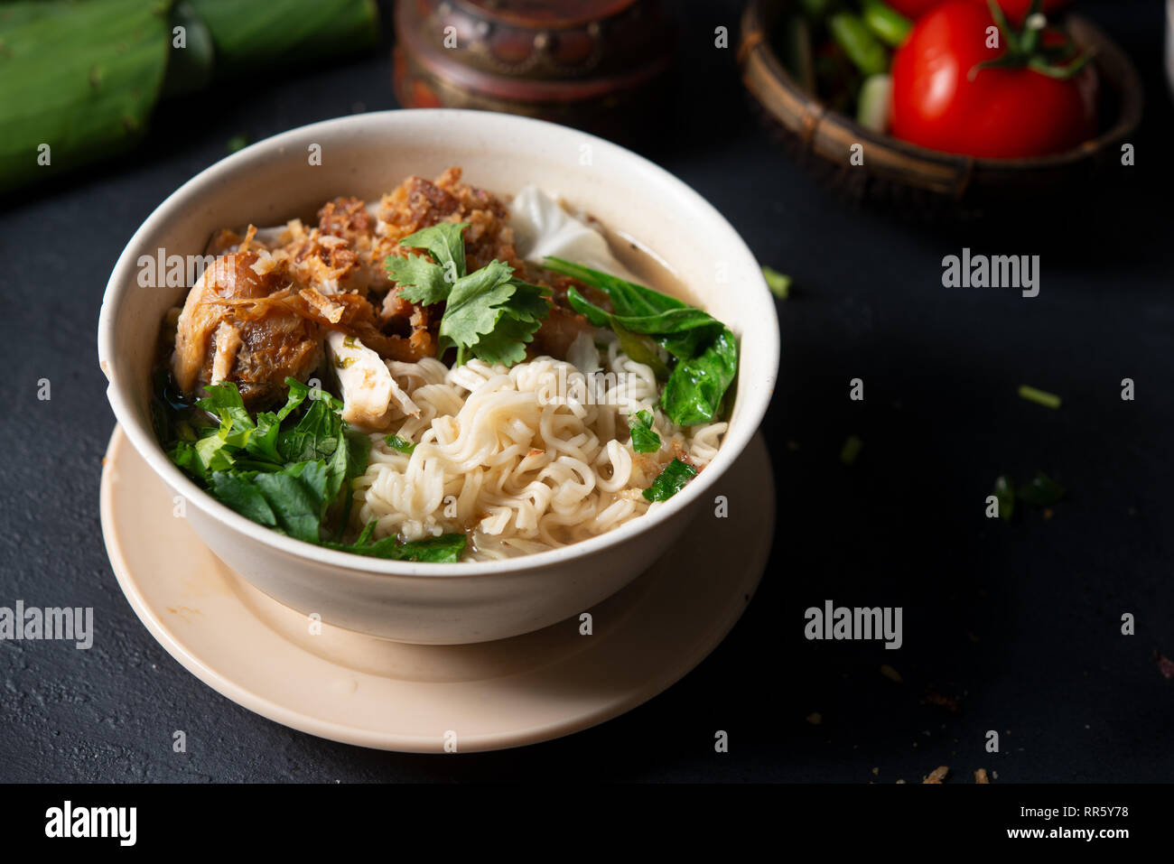 Asiatische Ramen Nudeln Suppe und Hühnchen in der Schüssel auf dunklem Hintergrund. Stockfoto
