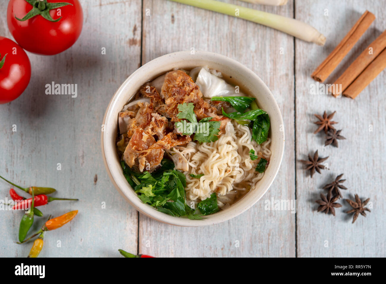 Asiatische Ramen Nudeln Suppe mit Gemüse und Huhn in der Schüssel. Ansicht von oben flach auf Holz- Hintergrund. Stockfoto