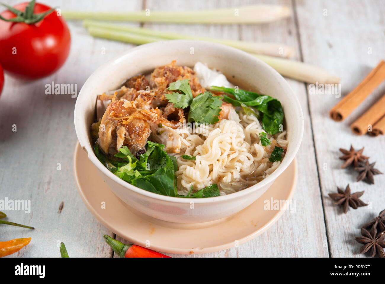 Asiatische Ramen Nudeln Suppe und Hühnchen in der Schüssel auf dunklem Hintergrund. Stockfoto