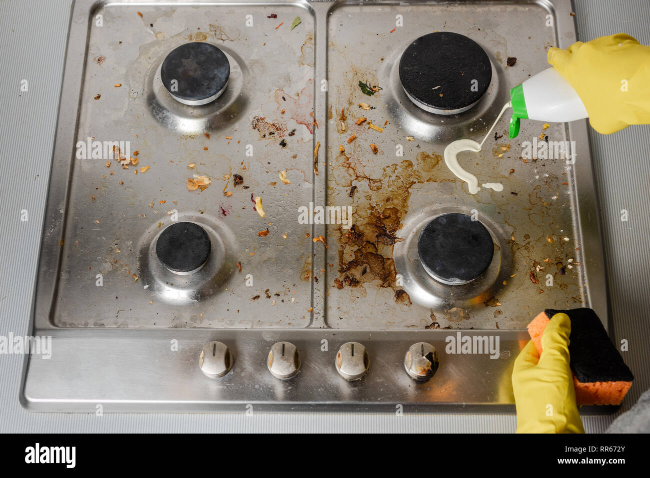 Anwendung von Reinigungsmitteln auf der Oberfläche einer schmutzigen Gas Herd. Blick von oben. Stockfoto