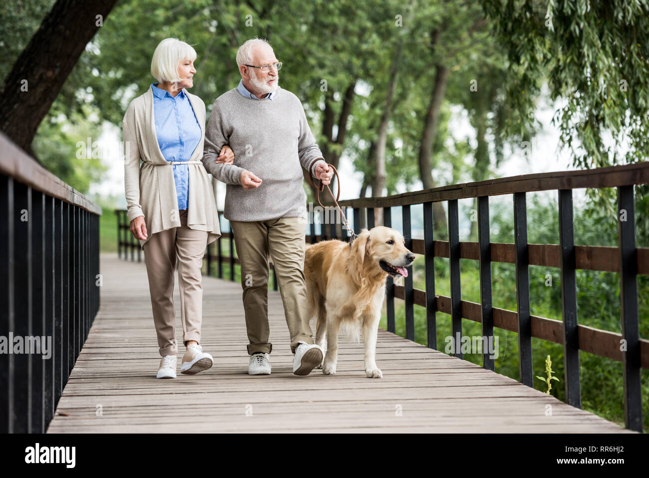 Gerne ältere Frau und Mann Wandern mit Hund im Park Stockfoto