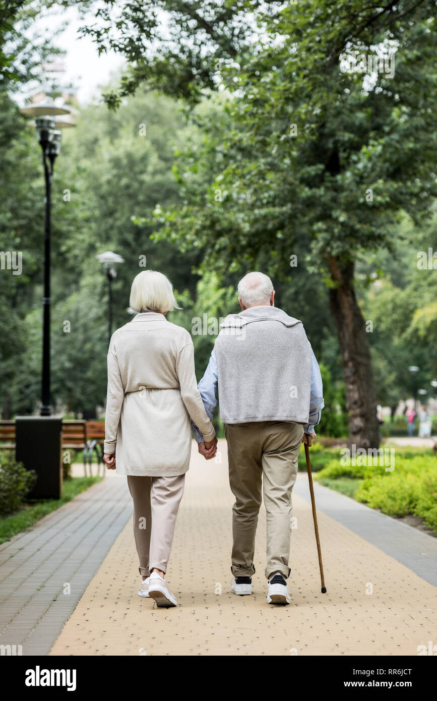 Rückansicht des stilvollen Älteres Paar beim Spaziergang im Park Stockfoto