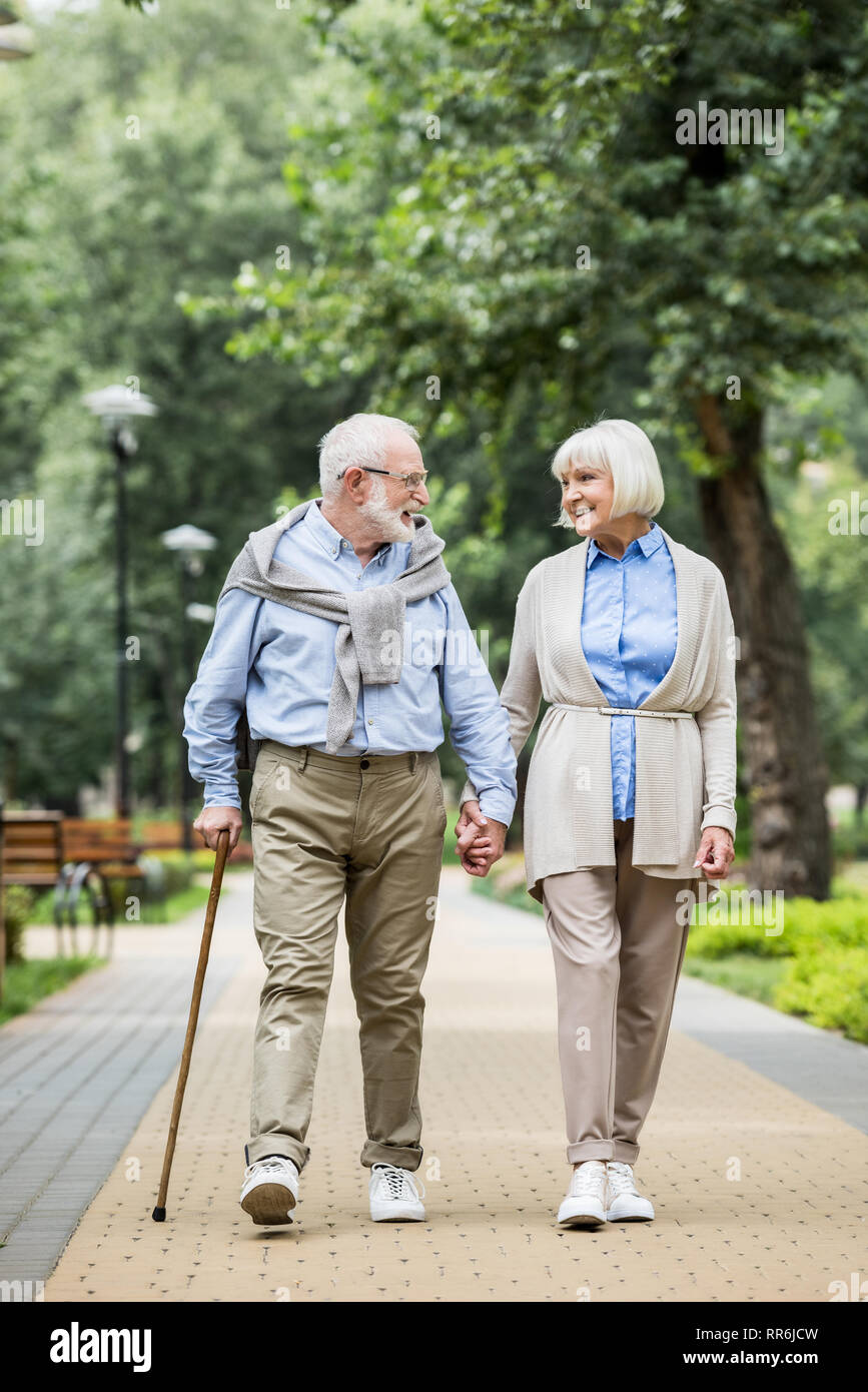 Lächelnd senior Paar sprechen beim Spaziergang im Park Stockfoto