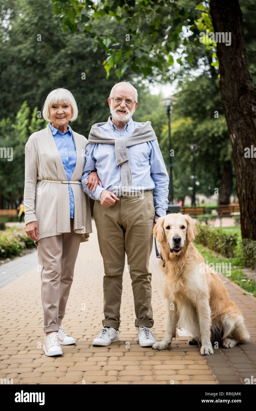 Glücklich lächelnde senior Paar mit niedlichen Hund im Park Stockfoto