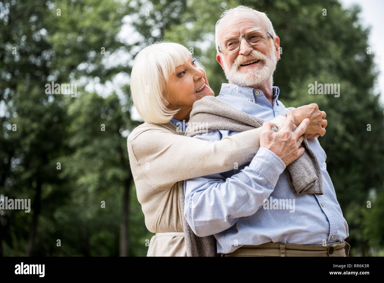 Gerne älteres Paar umarmen und lächelnd in Park Stockfoto