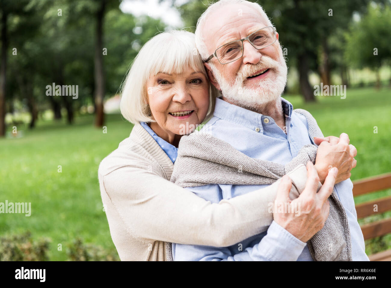 Gerne ältere Frau umarmen lächelnden Mann im Park Stockfoto
