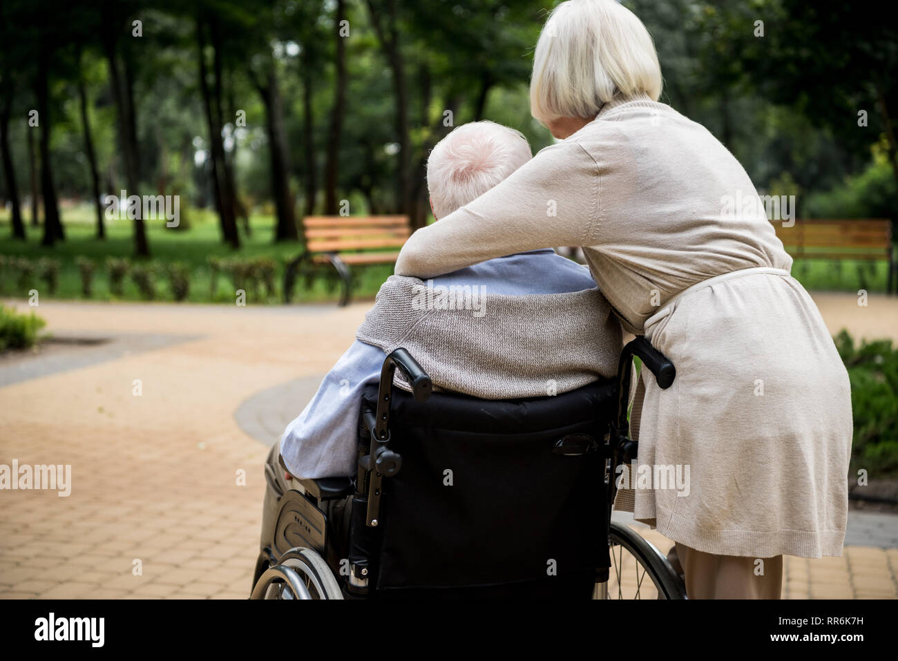 Rückansicht der älteren Frau mit Mann im Rollstuhl im Park Stockfoto