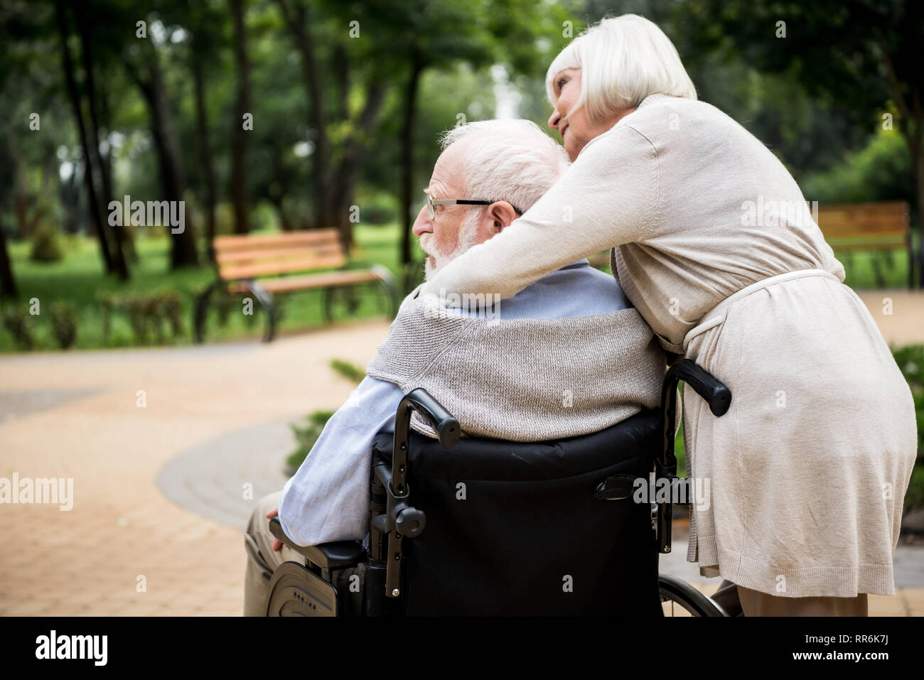 Ältere Frau mit Mann im Rollstuhl im Park Stockfoto
