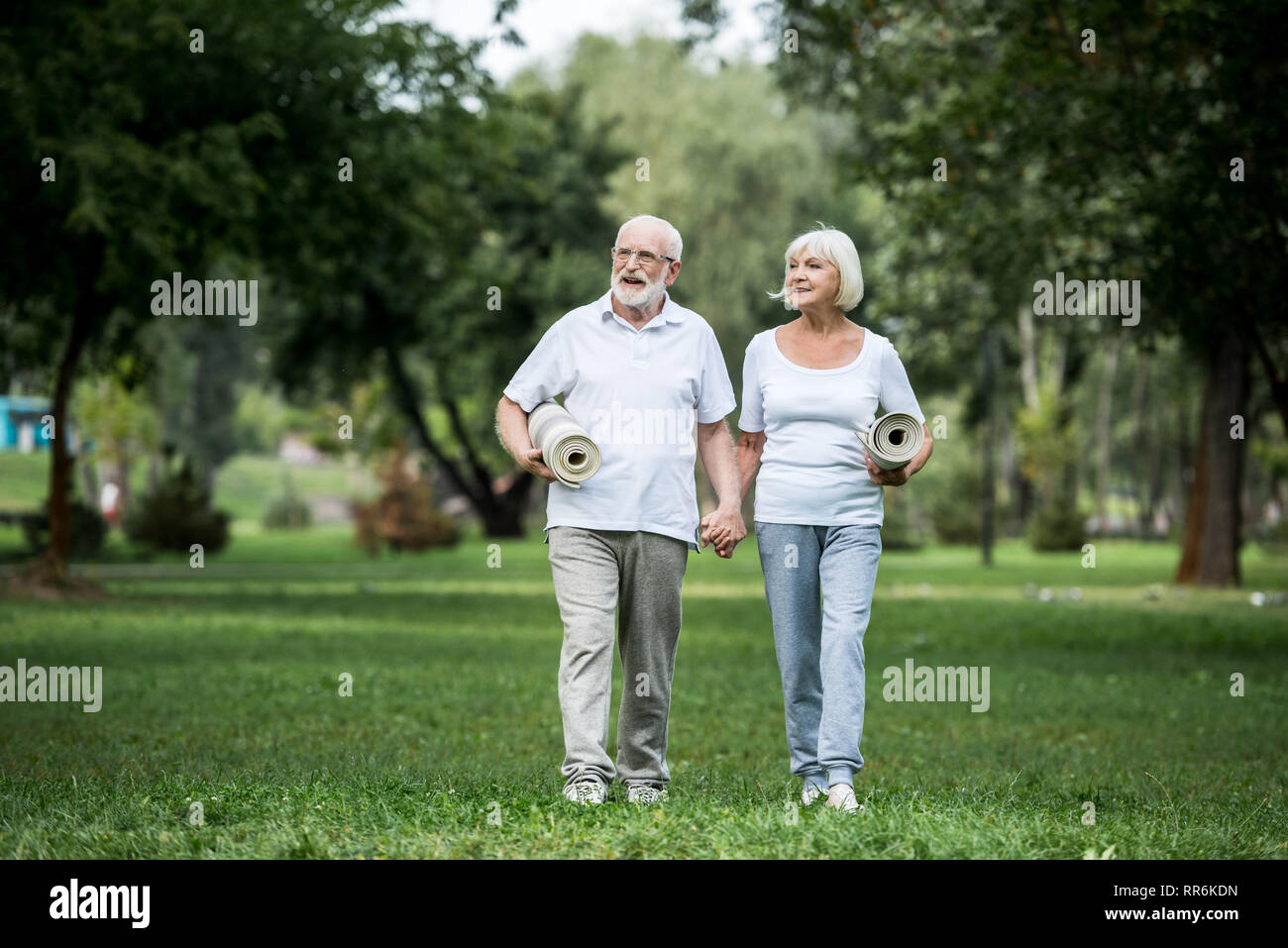 Gerne älteres Paar im Park und halten fitness Matten Stockfoto