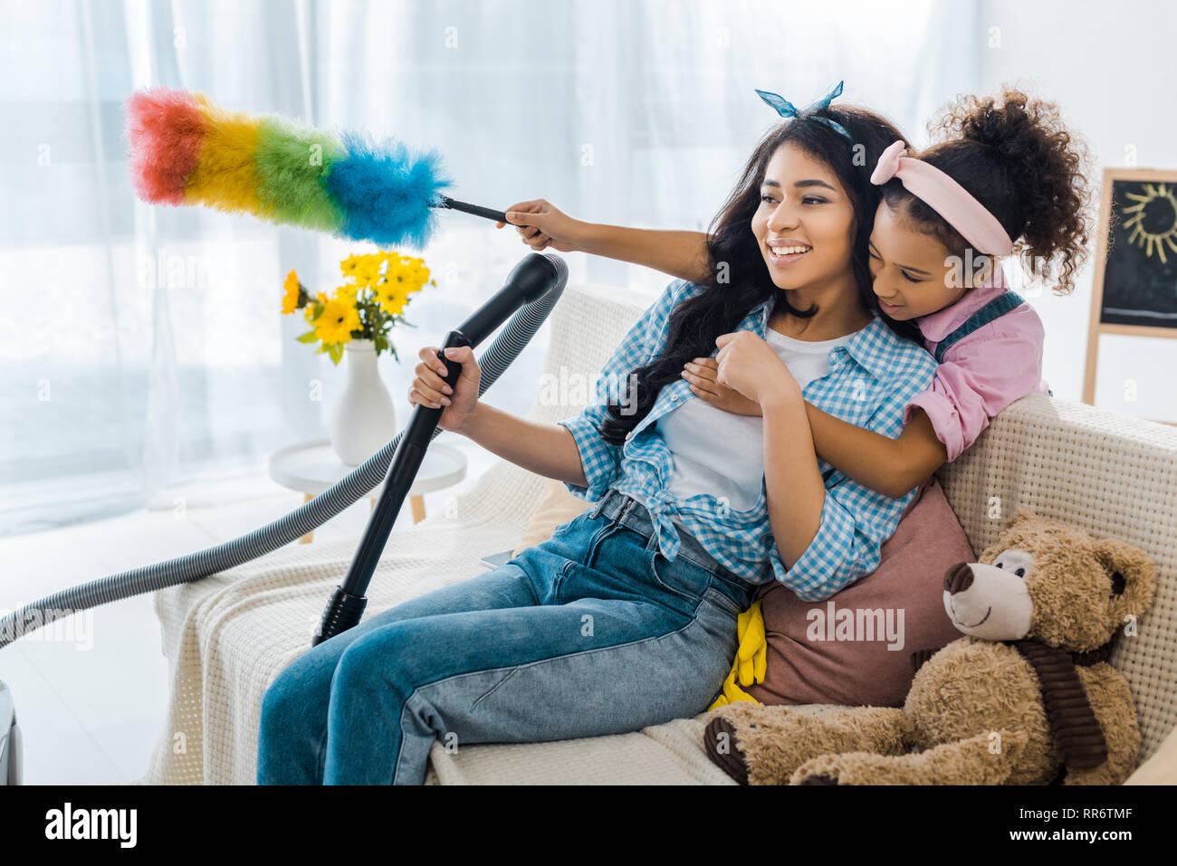 Cute afrikanische amerikanische Kind umarmen Mutter aus zurück halten bunte Duster Stockfoto