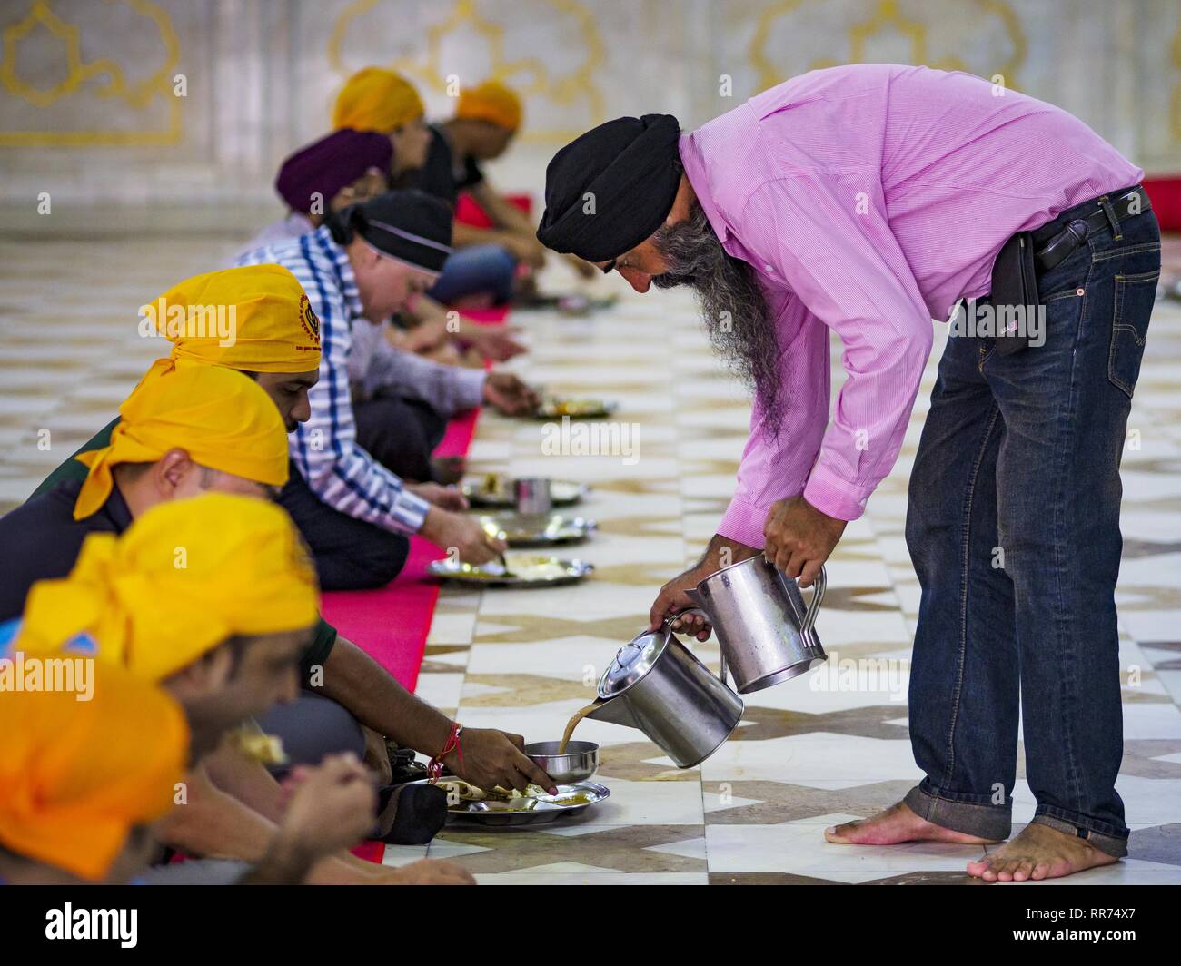 Bangkok, Bangkok, Thailand. 25 Feb, 2019. Ein freiwilliger gießt heißen Tee für Männer essen während der Morgen'' Langar'' (gemeinsames Essen) am Gurdwara Siri Guru Singh Sabha. Die gurdwara dient über 500 kostenlose Mahlzeiten von Montag bis Samstag und über 1.000 kostenlose Mahlzeiten an Sonntagen. Obwohl die Sikhs nicht Vegetarier sind, die langar Mahlzeiten sind Vegetarier und jeder kann sie ohne Verstoß gegen ein religiöses Edikt auf Diät. Die Mahlzeiten sind für alle, die Spaziergänge in den Gurdwara, unabhängig von ihrer Religion oder Nationalität. Die gurdwara Siri Guru Singh Sabha in Bangkok ist eine der größten Sikh Sikh (t Stockfoto