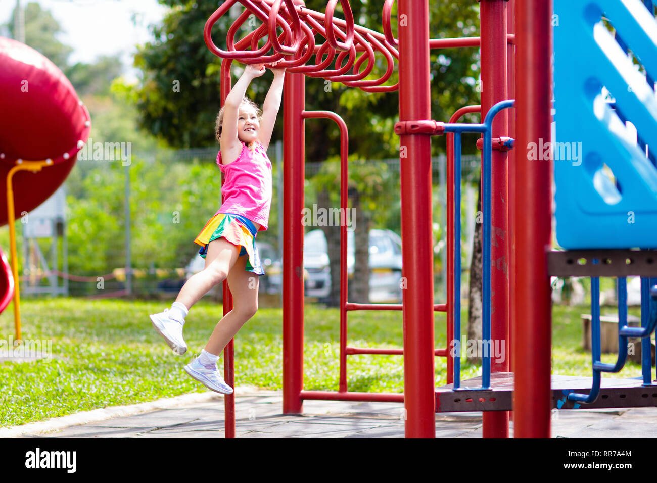 Kind auf Monkey Bars. Kind in der Schule Spielplatz. Kleines Mädchen hängen an Gym activity center von Vorschule spielen. Gesunde Aktivitäten für Kinder Stockfoto