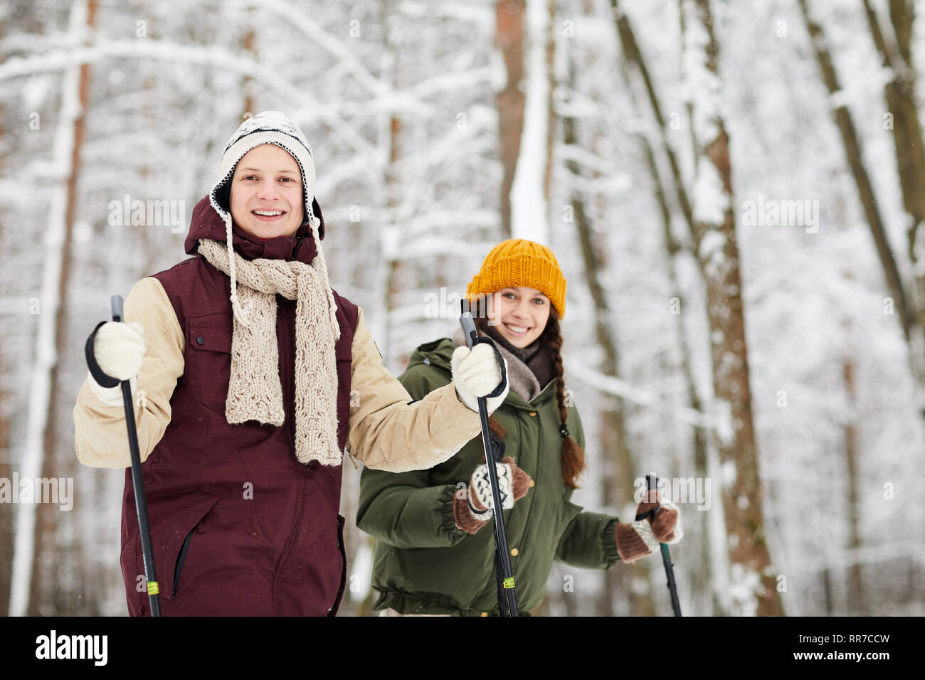 Lächelndes Paar Skifahren im Wald Stockfoto