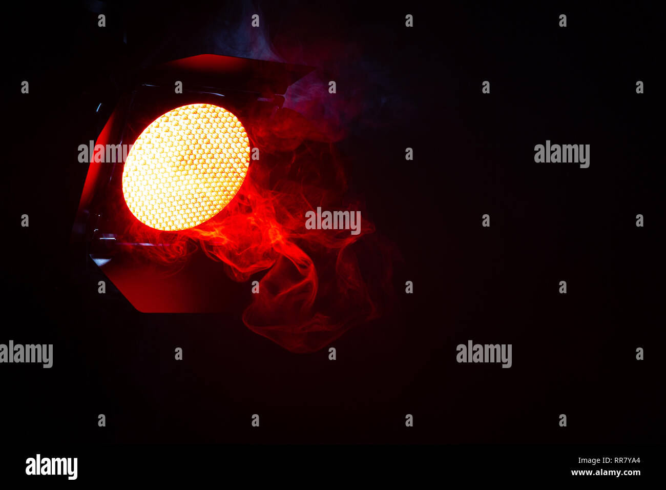 Rotes Licht mit Rauch auf dunklem Hintergrund. Ausrüstung für Photo Studio. Stockfoto