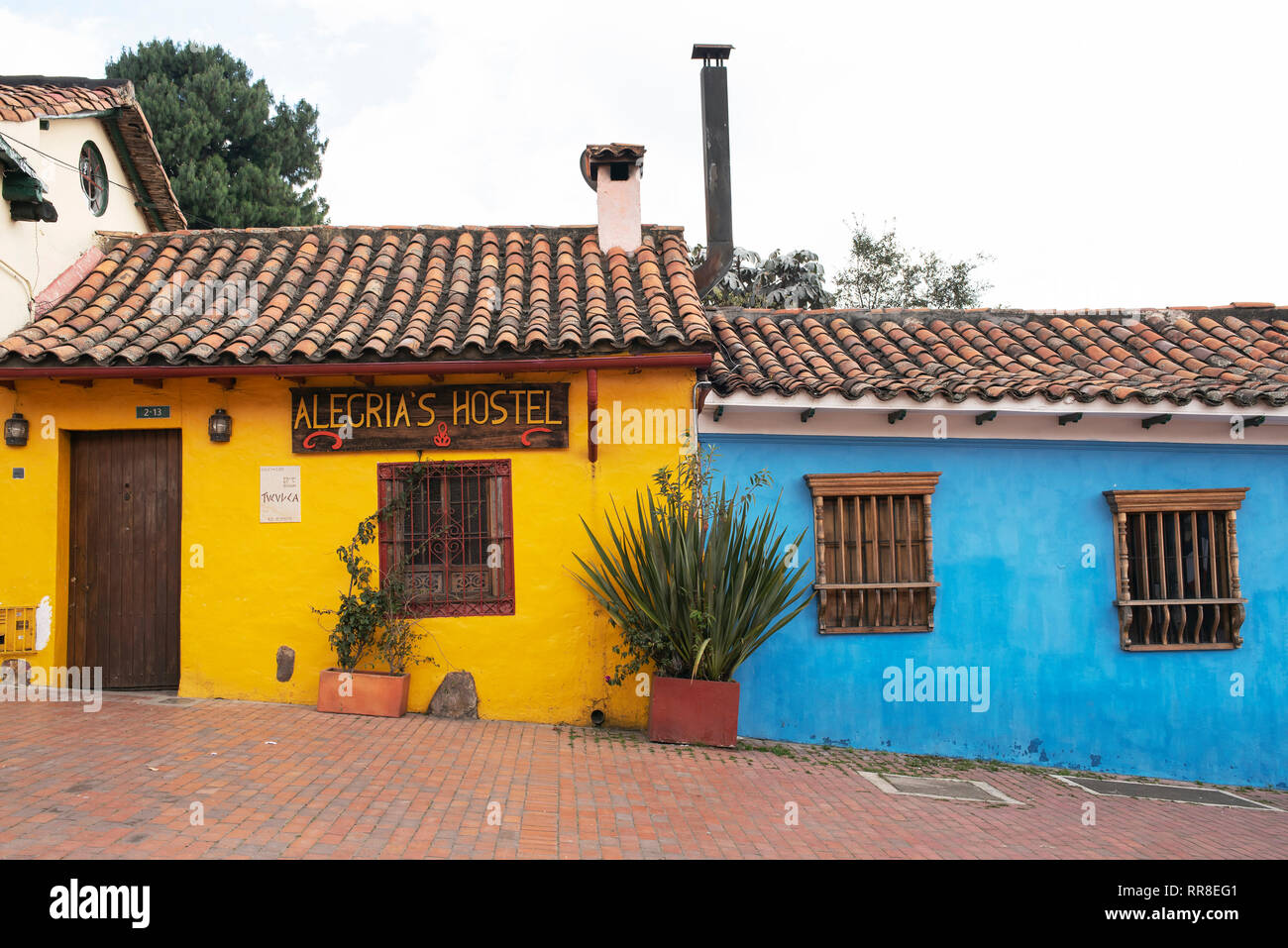 Bunte Häuser aus der Kolonialzeit in La Candelaria, dem historischen Zentrum von Bogota, Kolumbien. (Die helle Fassade des Alegria's Hostel in der Calle 9). Sep 2018 Stockfoto