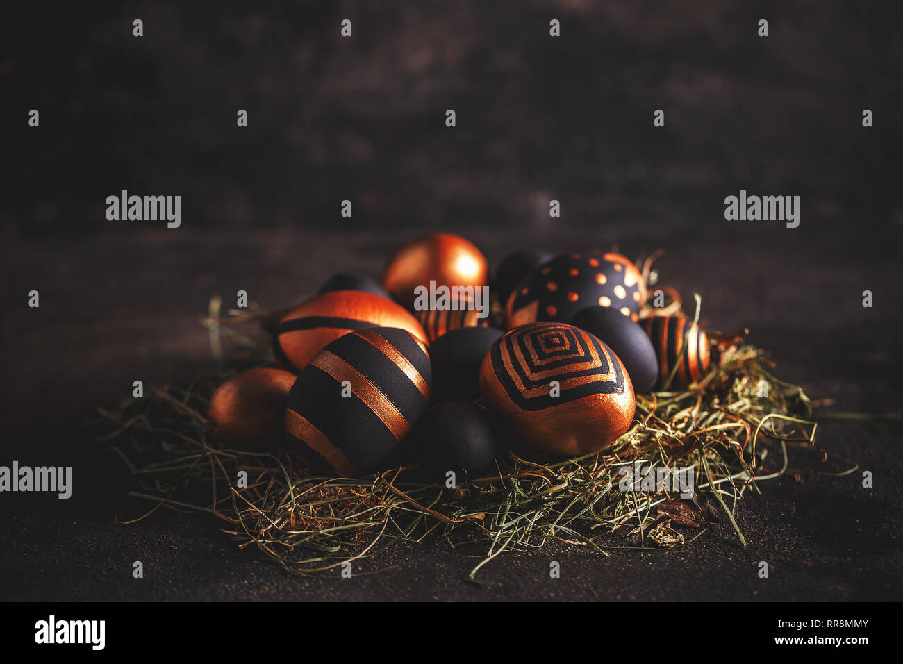 Ostern Grußkarte. Schwarze und goldene Eier mit Streifen und Punkten auf schwarzem Hintergrund Stockfoto