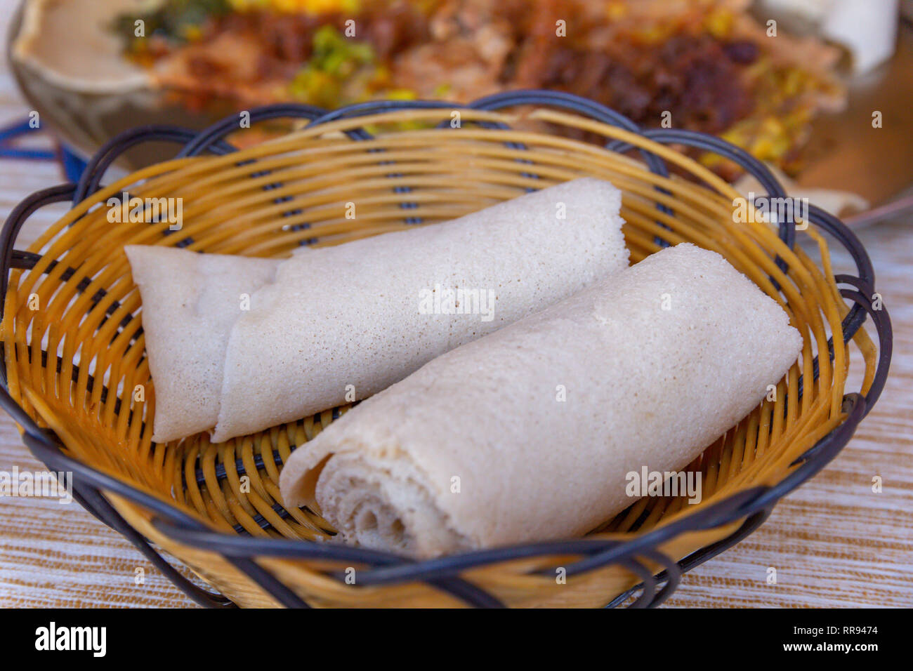 Afrikanische Speisen. Walzen der Injera - ein sauerteig Fladenbrot aus teff Mehl gemacht. Es ist dem nationalen Gericht aus Äthiopien, Eritrea, Somalia und Dschibuti Stockfoto