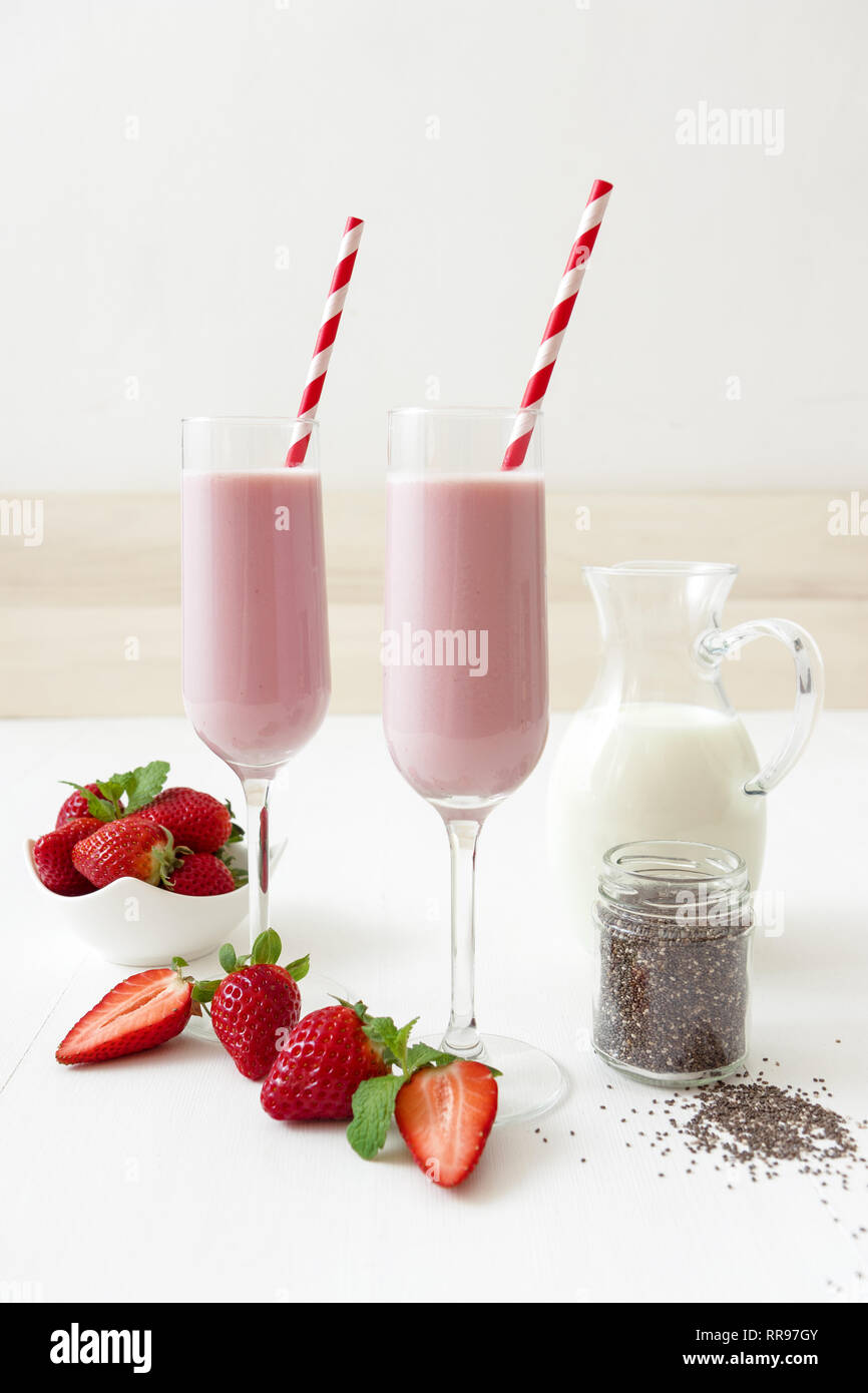 Strawberry Smoothie. 2 Gläser Erdbeer Milchshake, Glas Krug Milch, kleines  Glas Chia Samen, Porzellan Schüssel mit Erdbeeren verziert w  Stockfotografie - Alamy