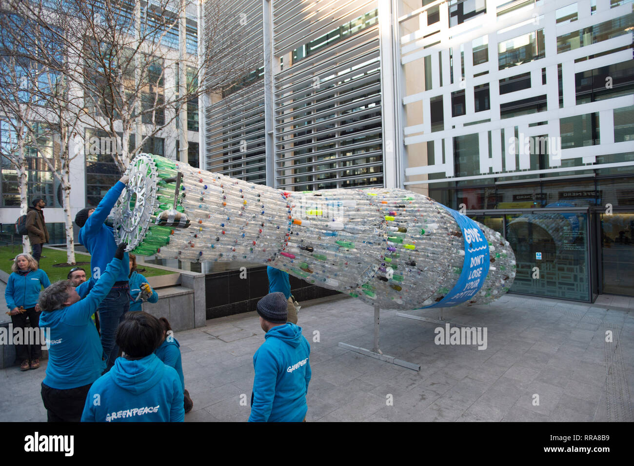 Greenpeace Aktivisten, mit einem 29 Meter langen Plastikflasche Artwork, im  Ministerium für Umwelt, Ernährung und Angelegenheiten des ländlichen Raums  im Home Office in London, die Flasche zu Umwelt Sekretär Michael Gove zu