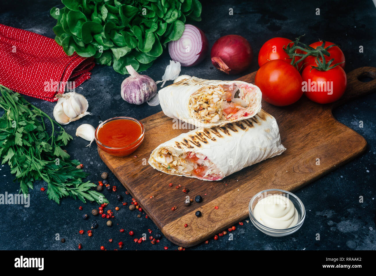 Döner Kebab (shawarma oder Döner wrap). Gegrilltes Hähnchen auf LAVASH (Fladenbrot) mit frischem Gemüse - Tomaten, grüner Salat, Paprika. Alte hölzerne backgr Stockfoto