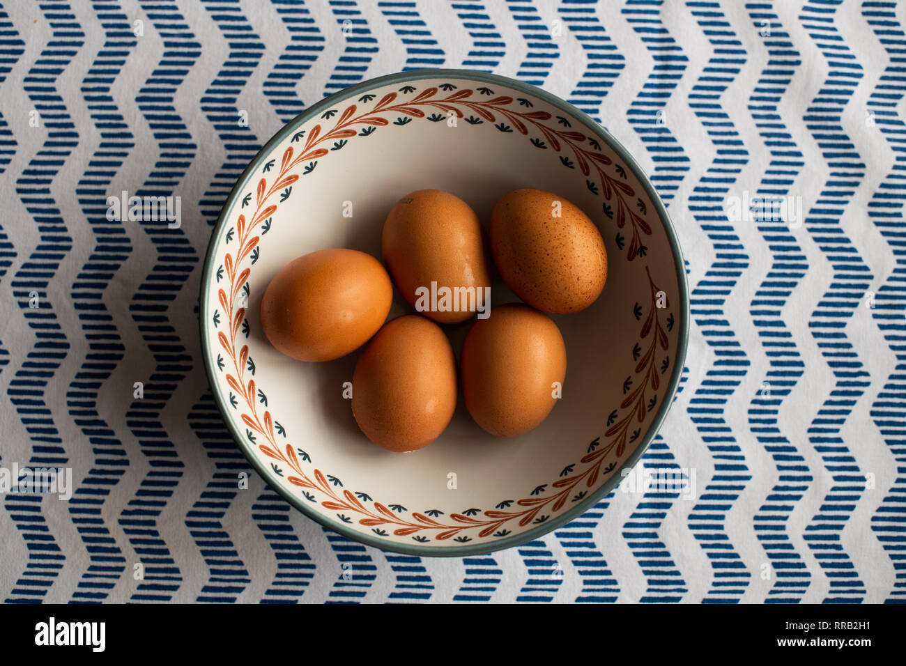 Schüssel Eier, 5 braune Eier in eine Schüssel geben. Stockfoto