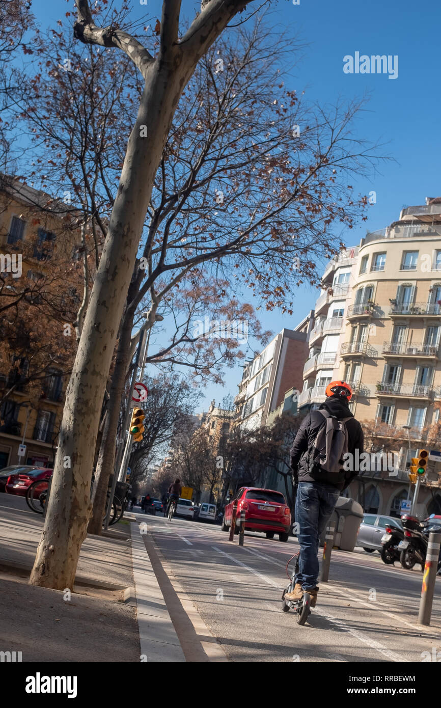 Junger Mann in Freizeitkleidung fahren auf elektrische Scooter auf der Überholspur der Stadt, Barcelona, Spanien. Ökologie Verkehr Konzept. Stockfoto