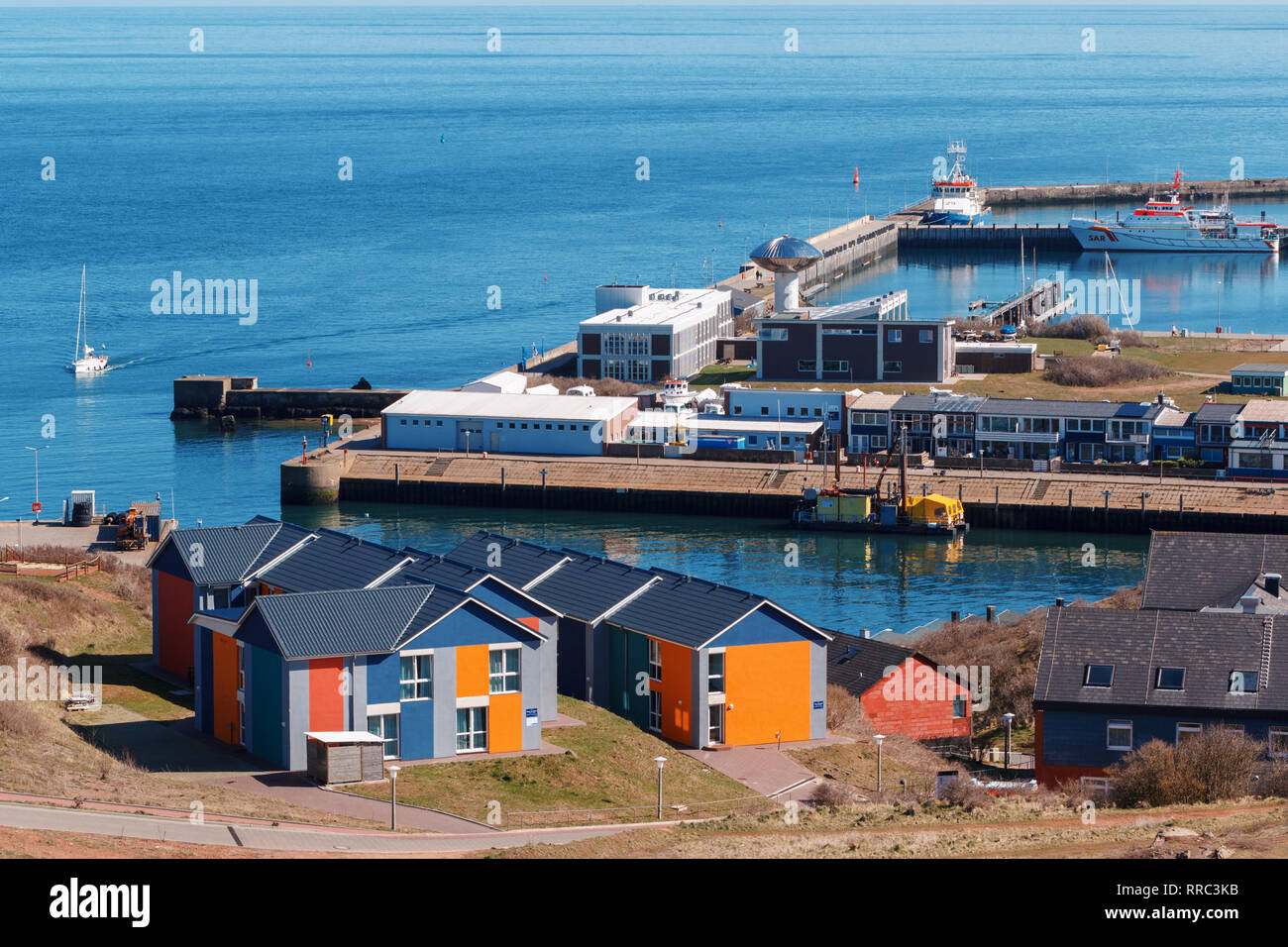 Hafen in Insel Helgoland, Deutschland, im nordischen Stil Häuser mit Boot und blauer Himmel, panorama Blick vom Hügel zu Nordsee Stockfoto