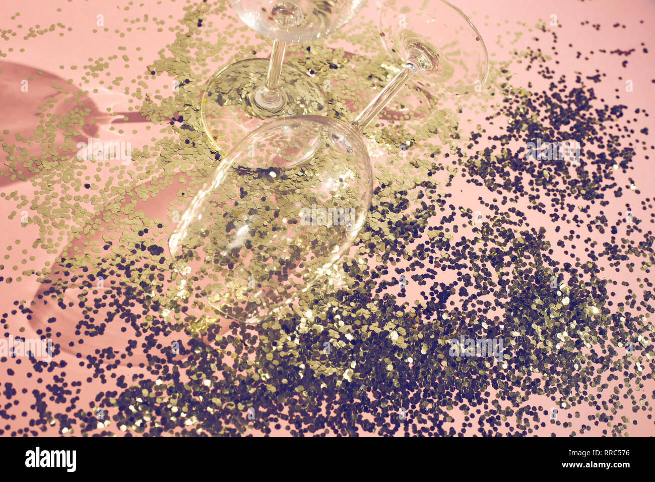 Leere Glas Pokale für Champagner im goldenen Konfetti auf dem Tisch. Festliche Hintergrund. Party Konzept Stockfoto