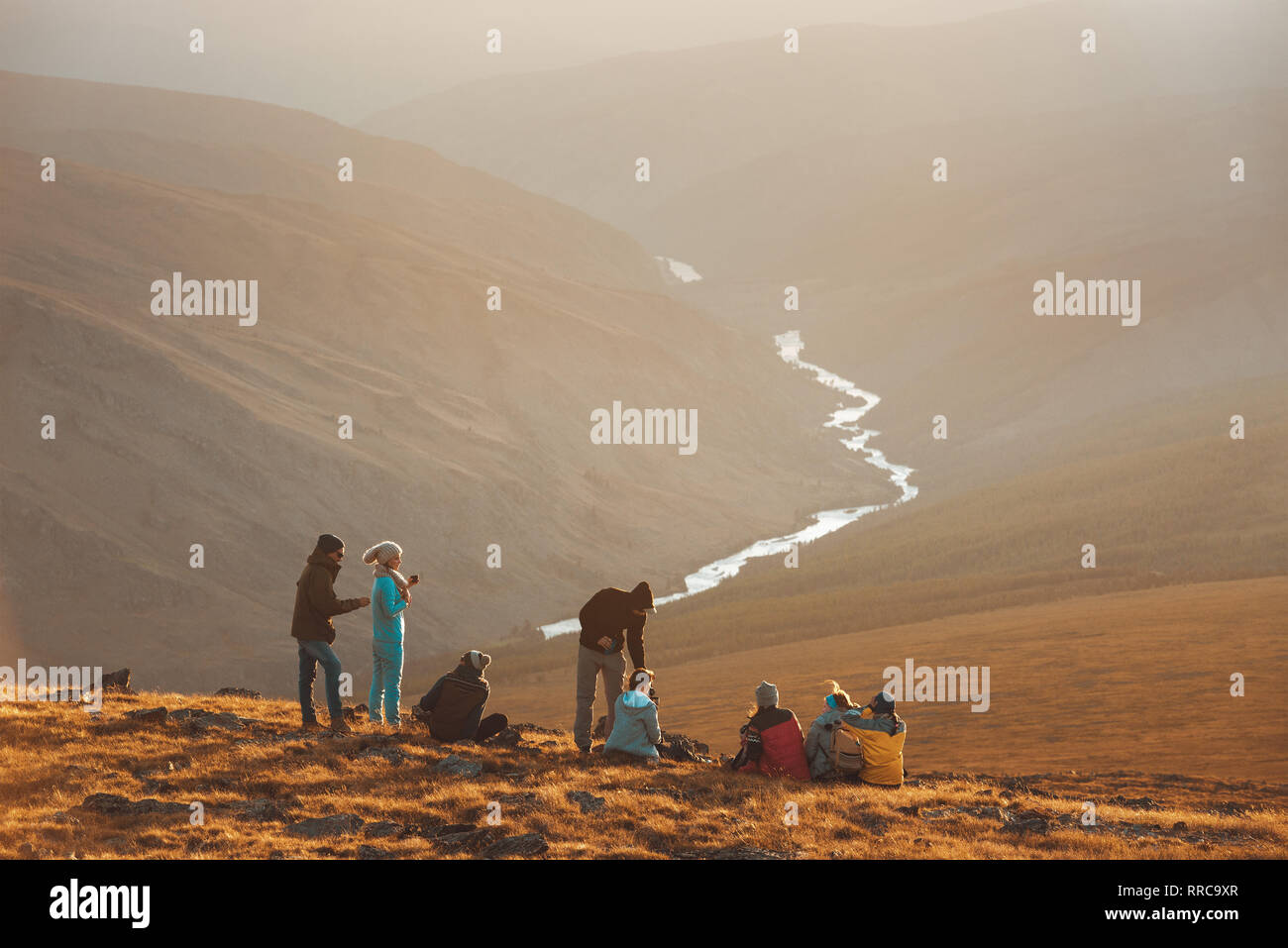 Große Gruppe von Freunden, die Völker auf den Berg nach oben und sieht bei Sonnenuntergang entspannen Stockfoto