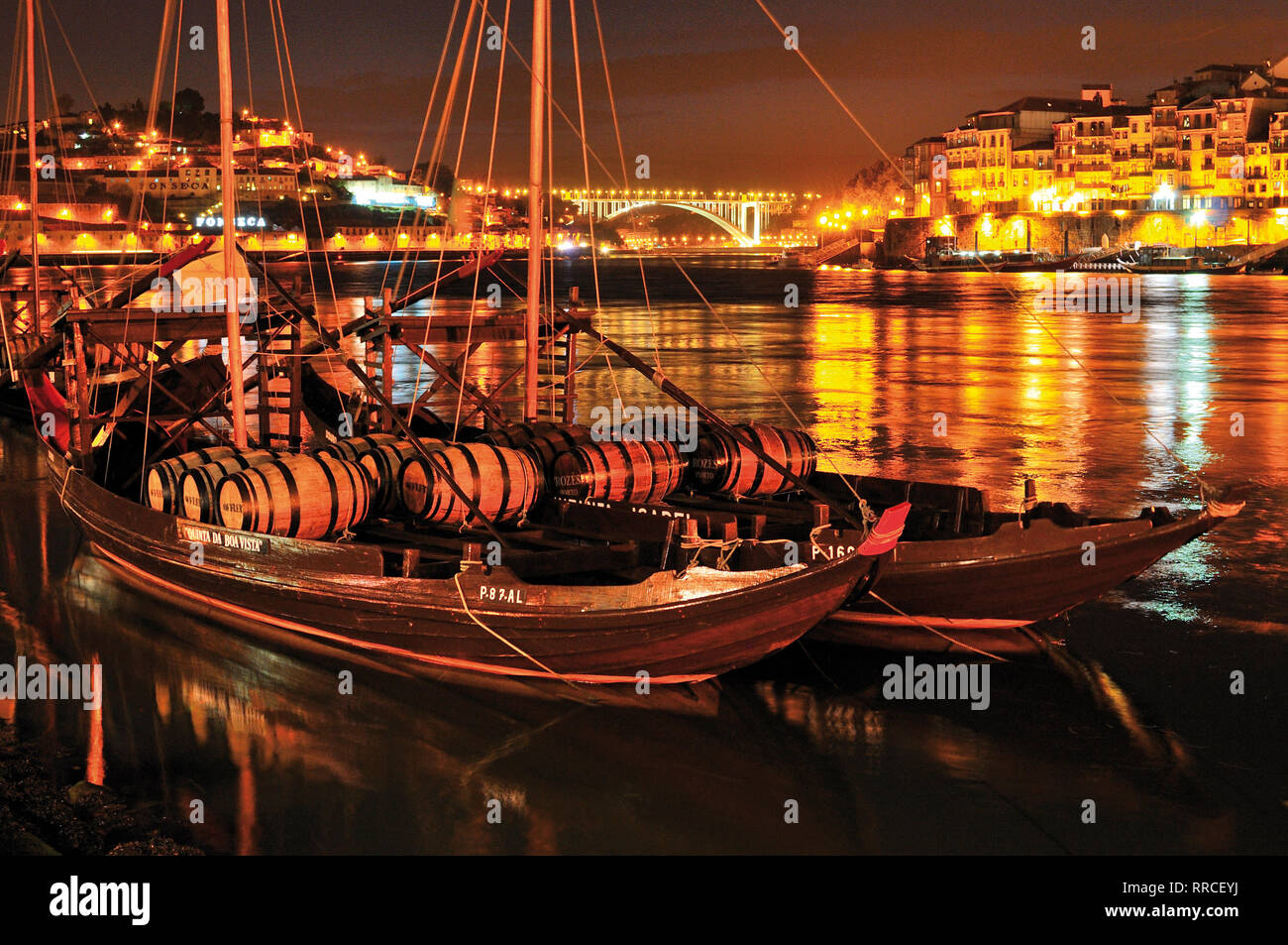 Historischer Hafen Wein Schiffe mit Weinfässern Verankerung auf dem Fluss Douro bei Nacht Stockfoto