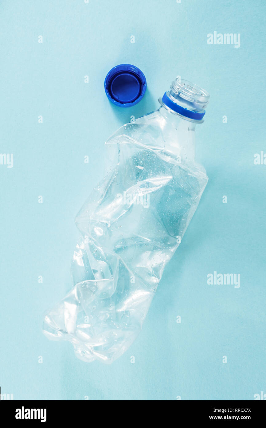 Kunststoffabfälle Konzept: verworfen zerknittert Wasserflasche in blauen Hintergrund, detaillierte Ansicht. nach oben Ansicht einer weggeworfenen single use Plastikflasche Darstellung Stockfoto