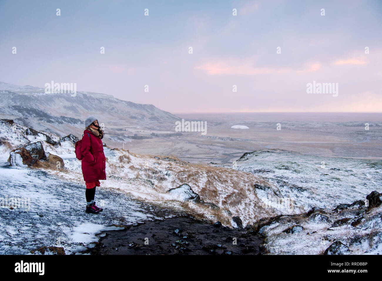 Weibliche Reisende auf einem Sonnenaufgang Winterwanderung in Island Stockfoto