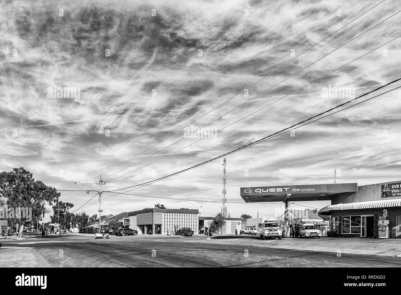 CARNAVON, SÜDAFRIKA, 31. AUGUST 2018: eine Straße, Szene, mit Fahrzeuge, Menschen und Unternehmen, die in Carnavon in der Northern Cape Provinz. Schwarzweiß Stockfoto