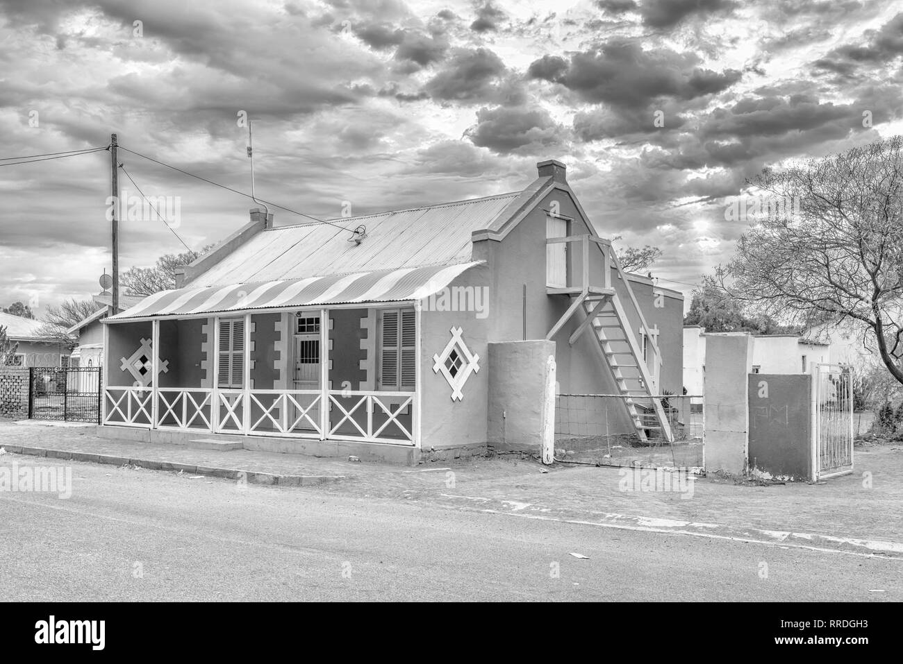 CARNAVON, SÜDAFRIKA, 1. September 2018: Am frühen Morgen street scene, mit einem historischen Haus, in Carnavon in der Northern Cape Provinz. Monochrom Stockfoto