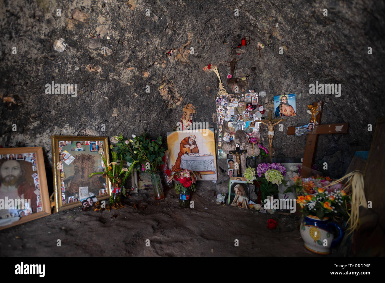 Fotos und Blumen im Speicher von geliebten Menschen neben einem Bild des Ehrwürdigen Bruder Pere Esteve an Pare Pere Hermitage. Denia, Spanien. Stockfoto