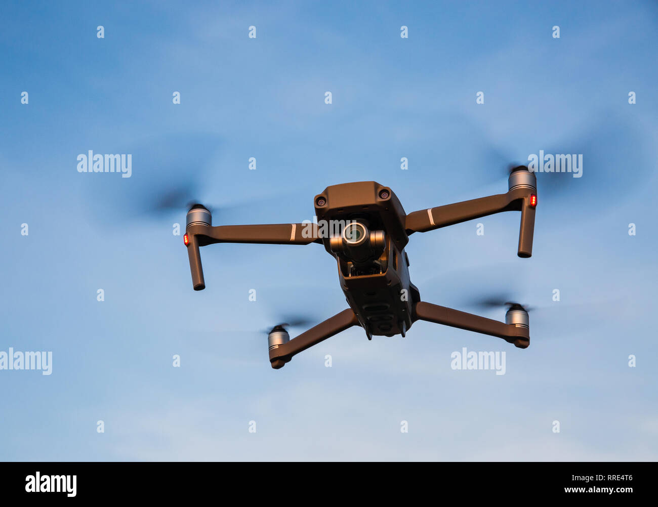 Ein niedriger Betrachtungswinkel eines futuristischen Drone quadcopter im Flug mit vier Propeller drehen und Drone schweben vor blauem Himmel Hintergrund Stockfoto Ein niedriger Betrachtungswinkel eines futuristischen Drone quadcopter im Flug mit vier Propeller drehen und Drone schweben vor blauem Himmel Hintergrund Stockfoto