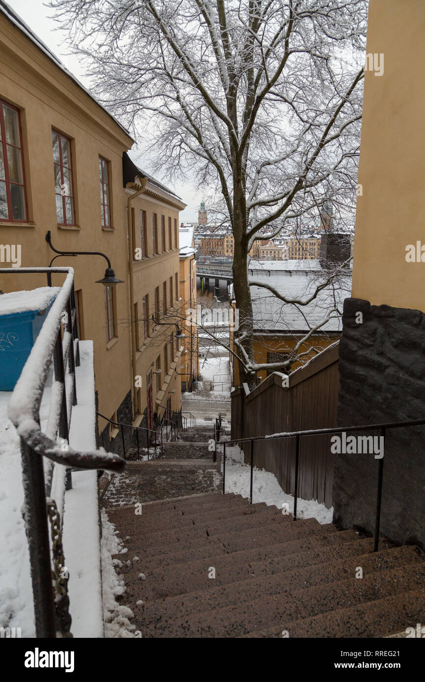 Schmale Treppe in der Mitte der alten Gebäude an einem verschneiten Wintertag mit Schnee schmelzen, Stockholm, Schweden Stockfoto