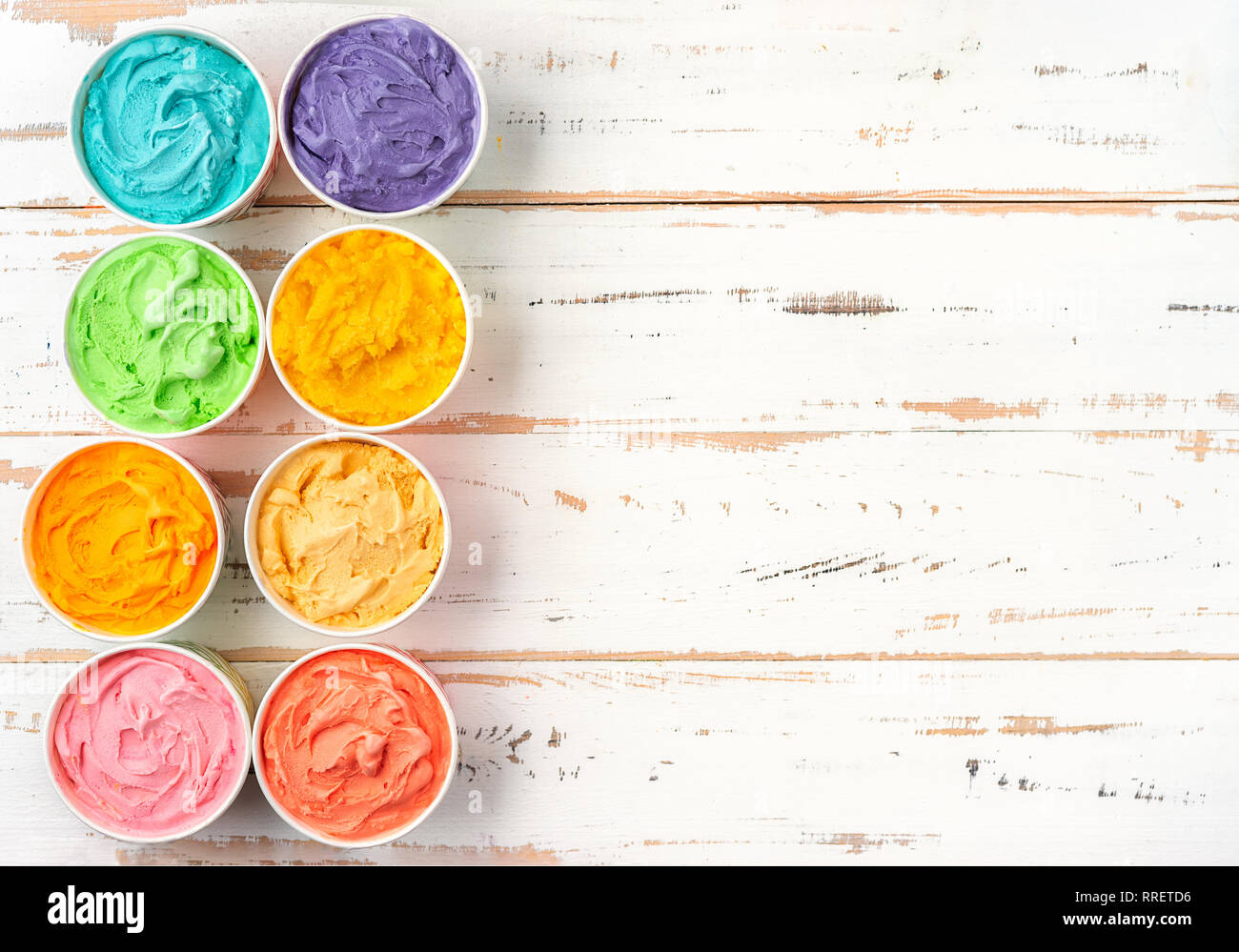 Blick von oben auf die bunten Regenbogen Eis in cups auf weißem Holz- Hintergrund Stockfoto